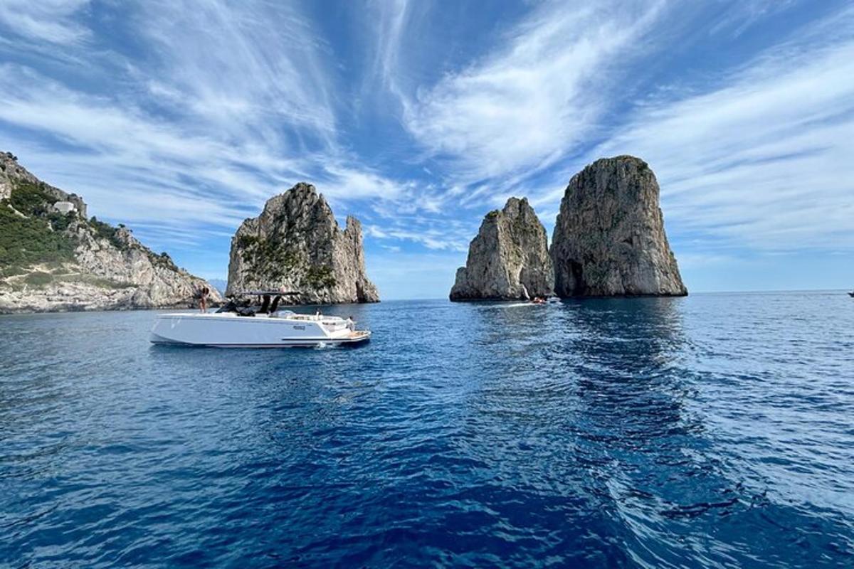 una barca in acqua vicino ad alcune grandi rocce