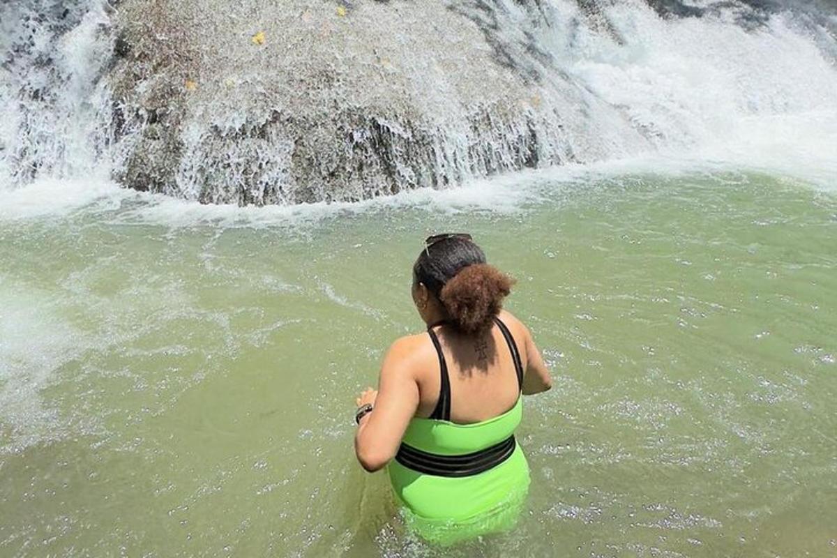 een vrouw die in het water staat bij een waterval