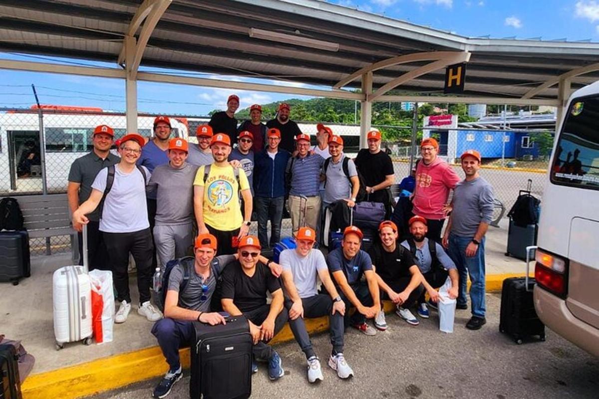 skupina mužů pózujících pro fotografii se svými zavazadly