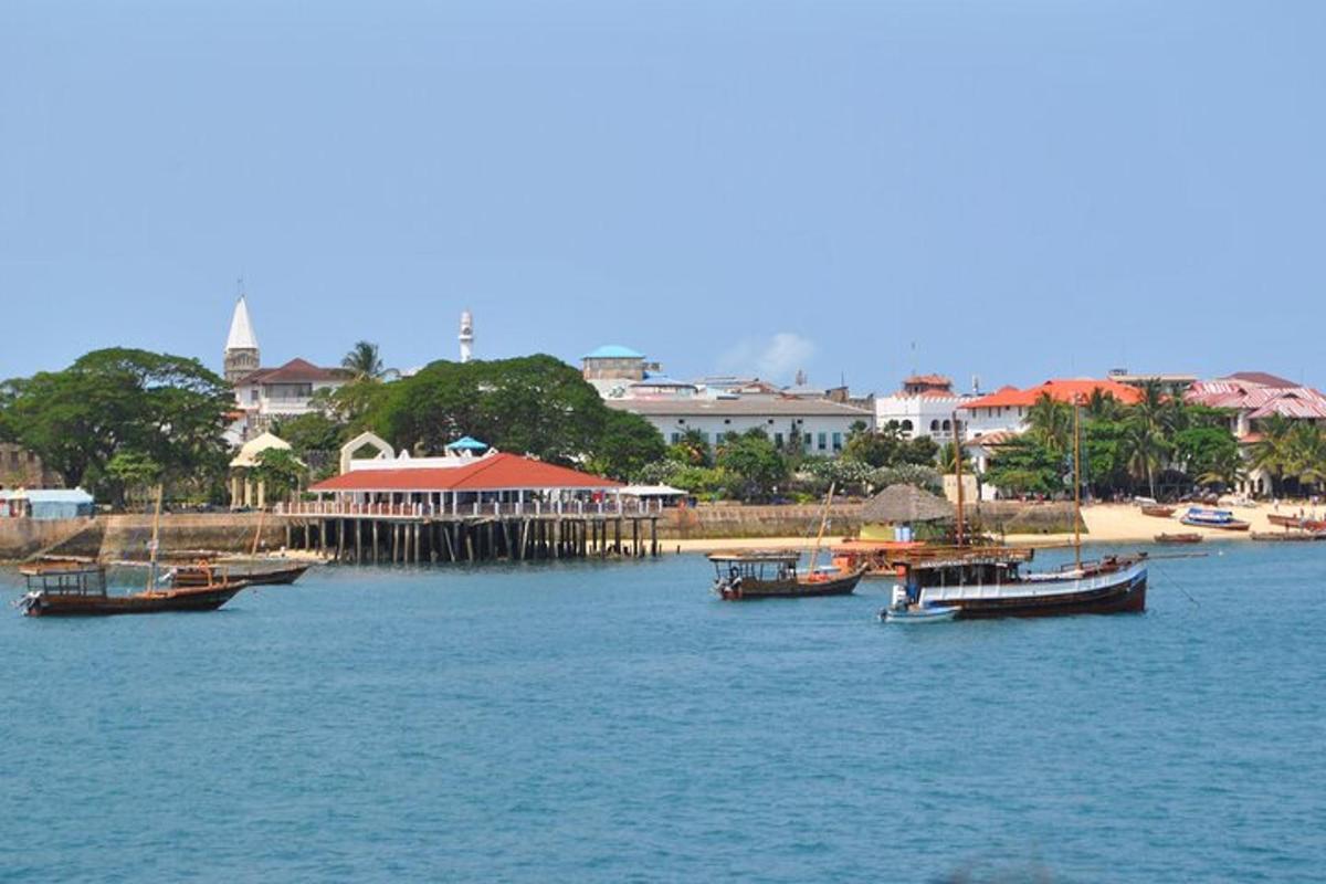 a group of boats in the water next to a beach