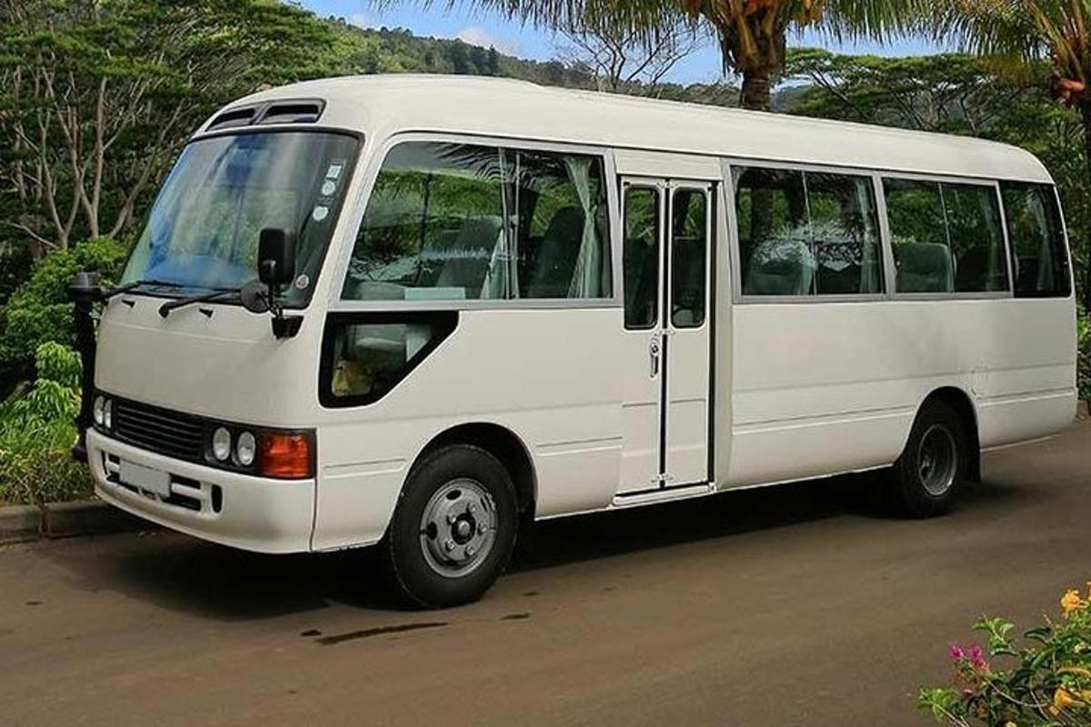 bílý autobus zaparkovaný na kraji ulice