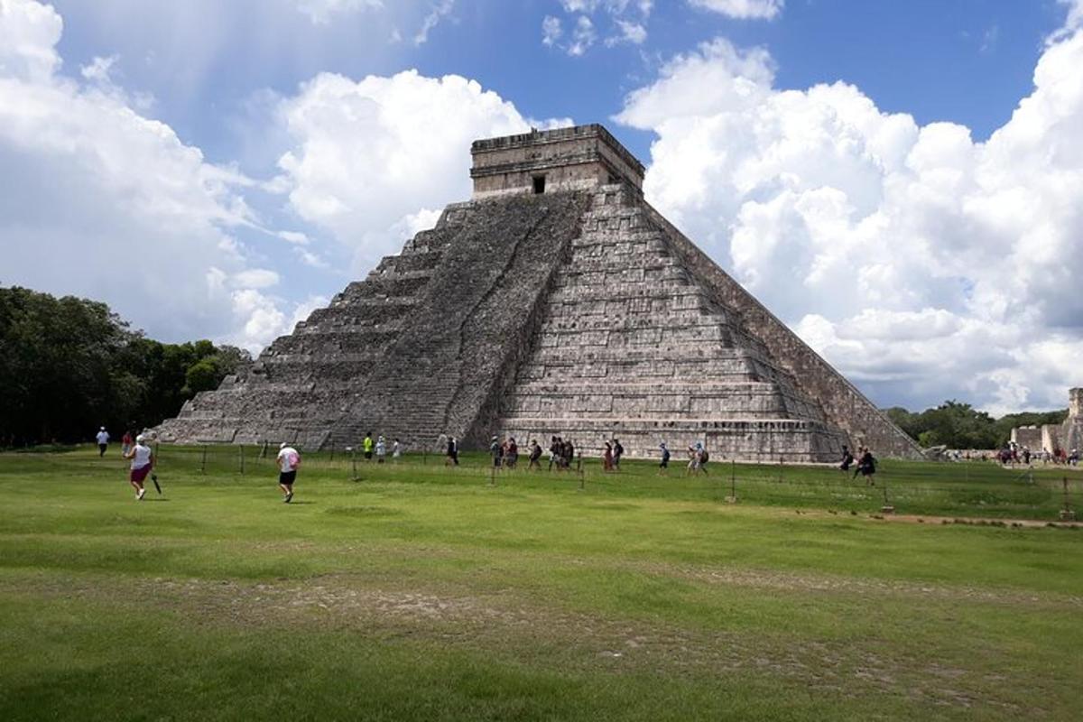 skupina ľudí kráčajúcich pred pyramídou