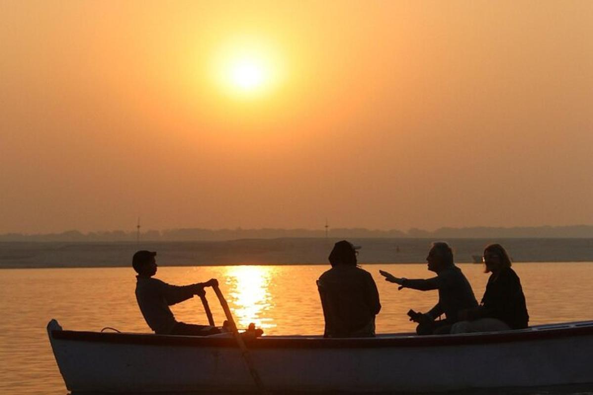 a group of people in a boat on the water at sunset