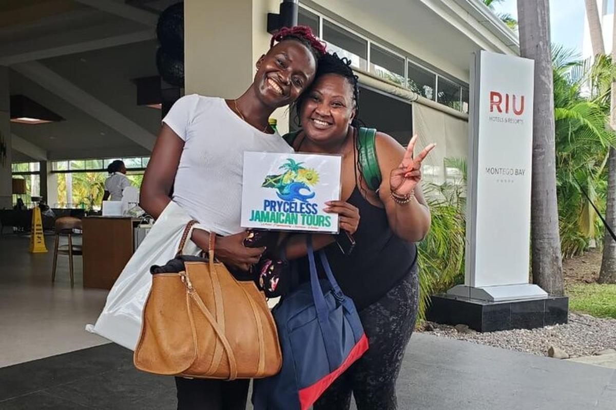 duas mulheres posando para uma foto segurando uma placa
