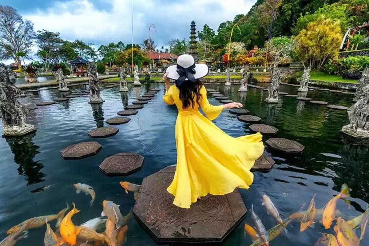 Una mujer con un vestido amarillo en un estanque con peces.