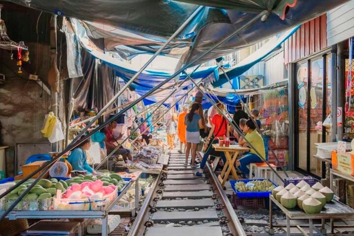 a market with people walking through a market with fruits and vegetables