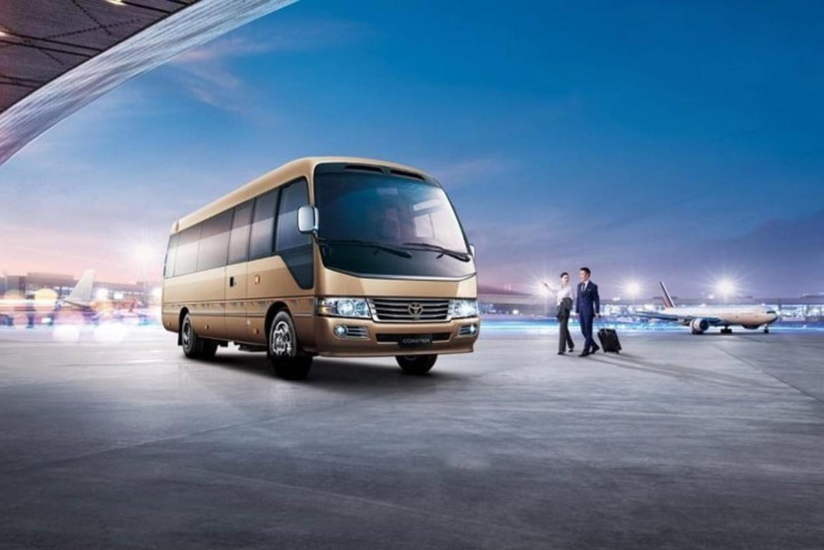 two people standing next to a bus in an airport