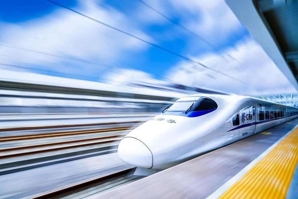 a white train is on the tracks at a train station