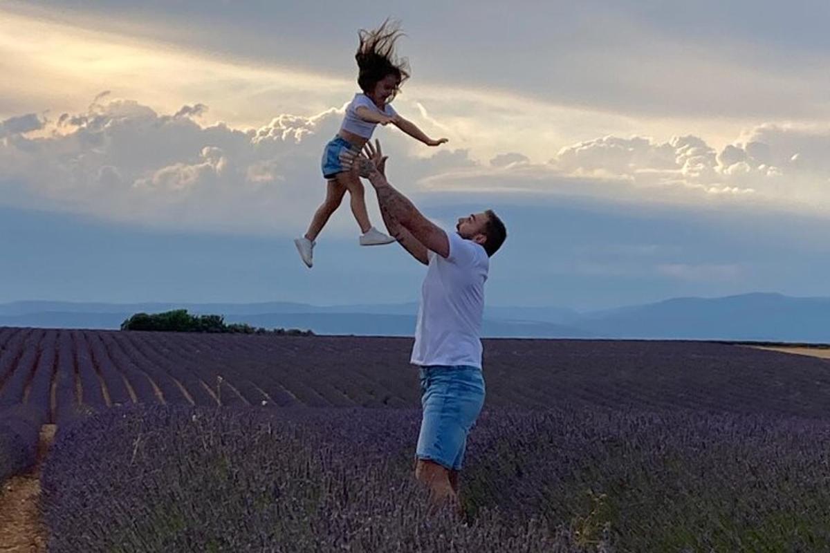 a man holding a little girl in a field