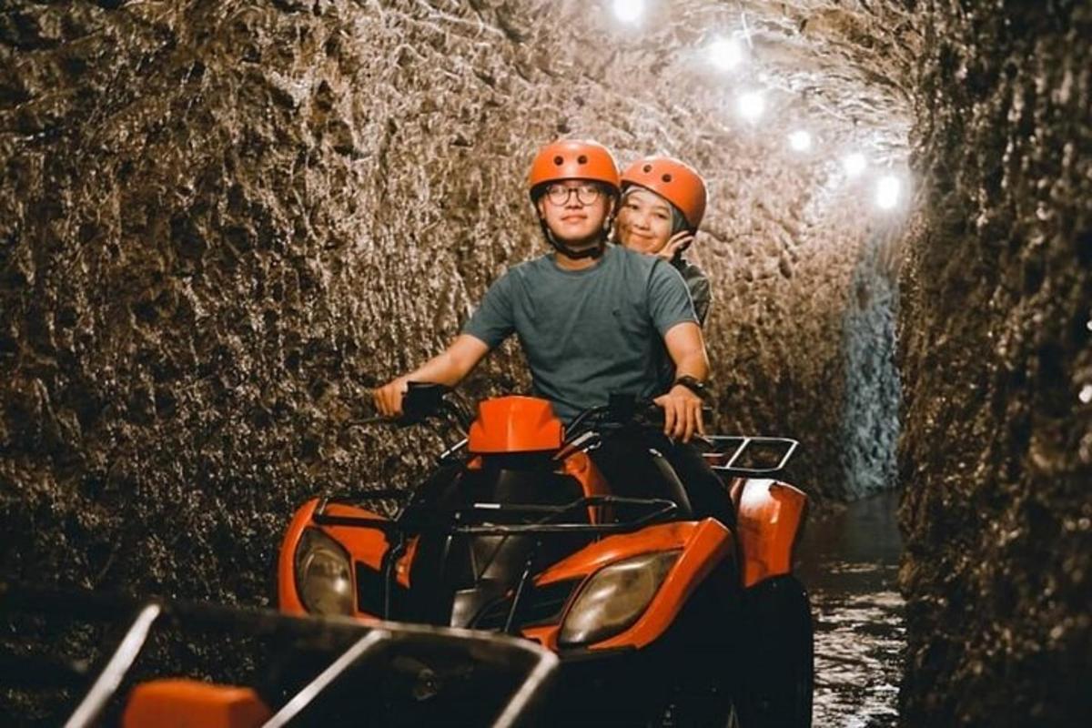 dua orang mengendarai ATV di dalam gua