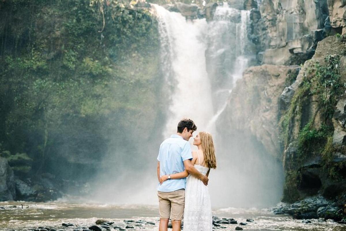 sepasang pengantin berdiri di depan air terjun