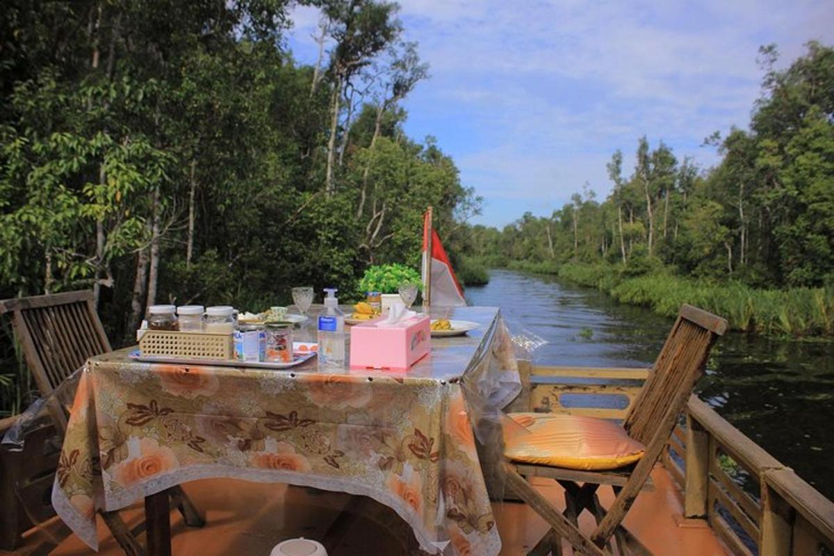 a table and chairs on a boat on a river