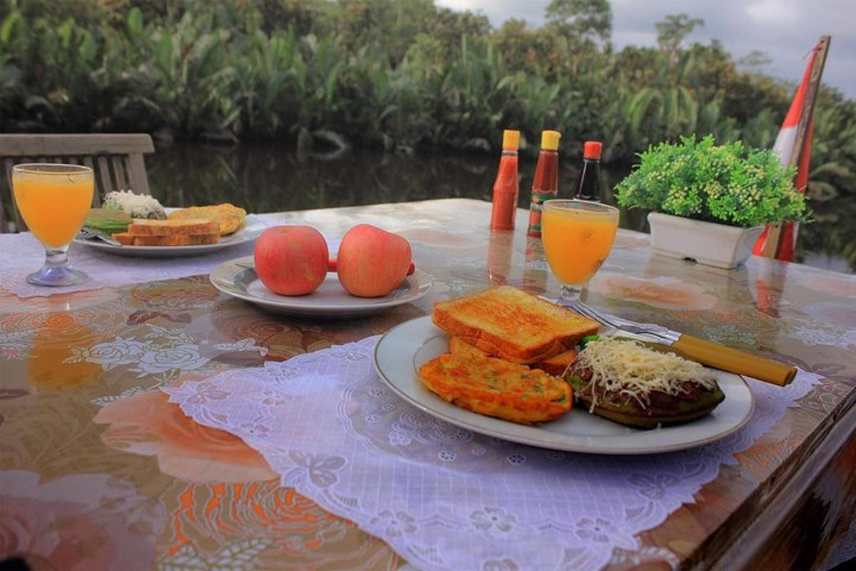 a table with plates of food and glasses of orange juice