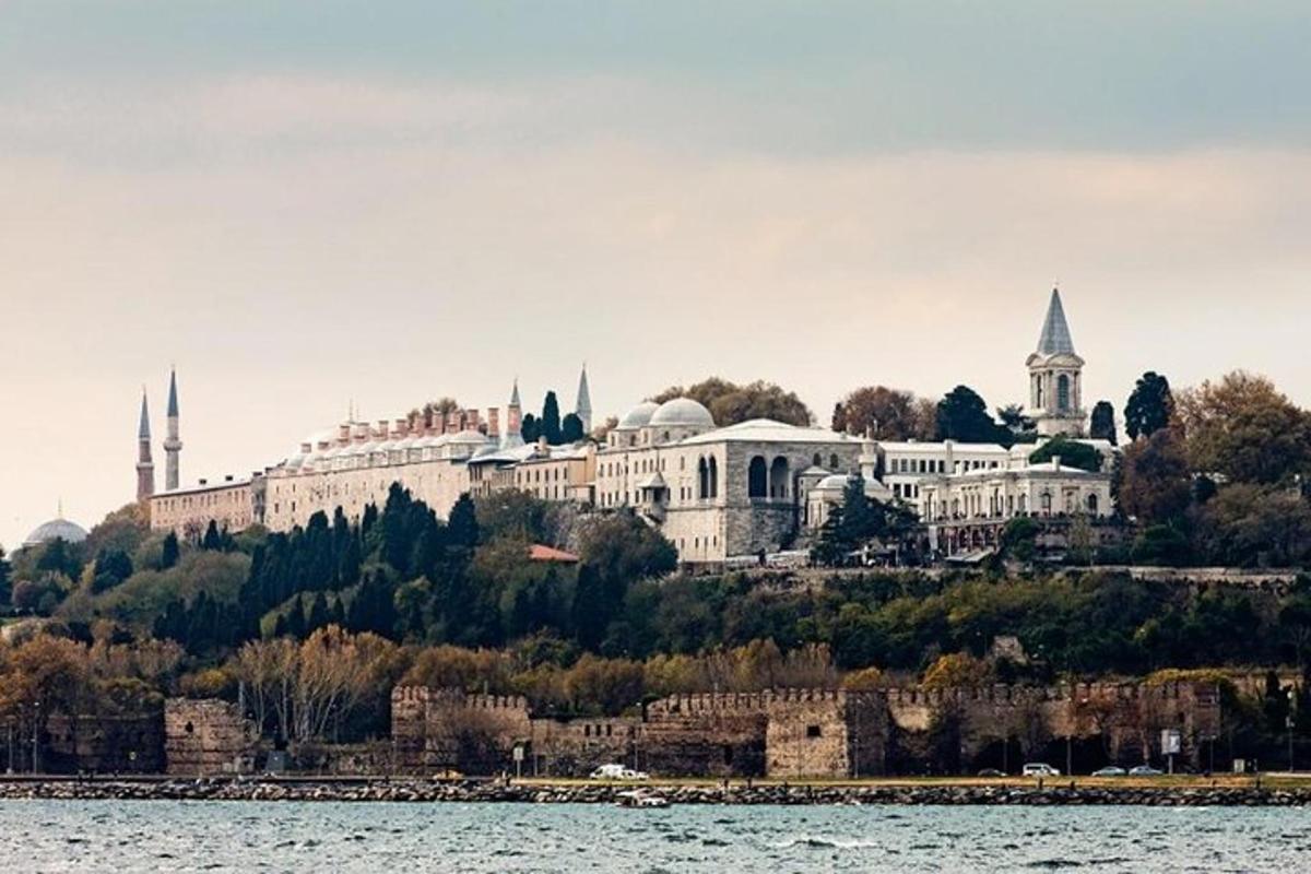 un grande edificio su una collina accanto a uno specchio d'acqua