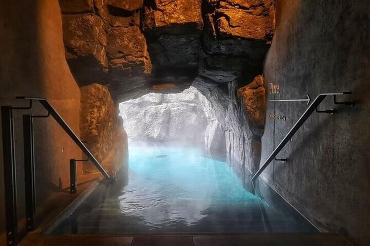 a tunnel with blue water in a cave