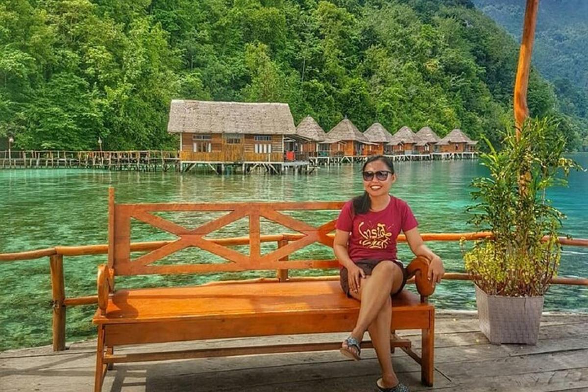a woman sitting on a bench in front of the water