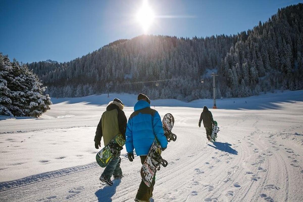 three people walking in the snow carrying snowboards