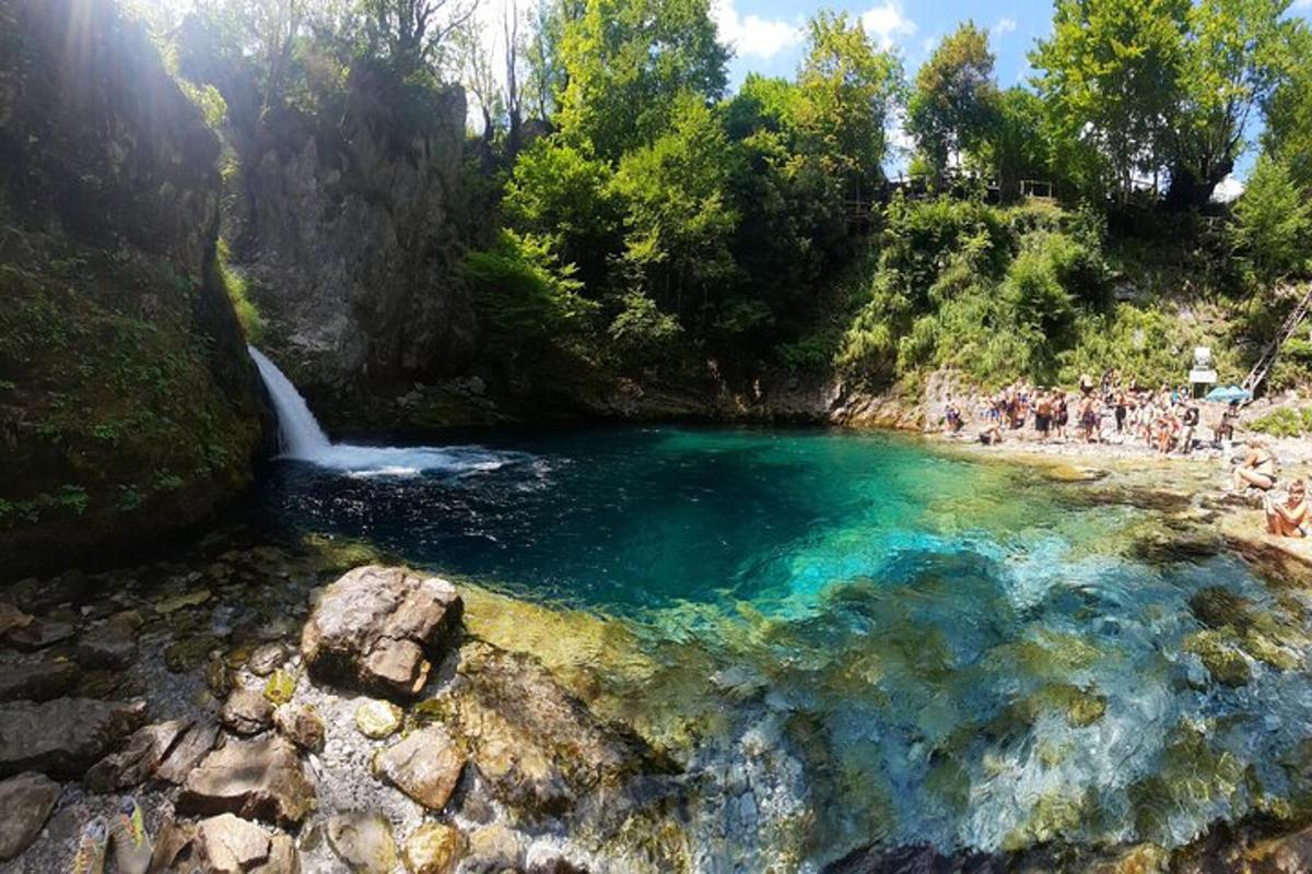 um grupo de pessoas em pé ao redor de uma piscina de água