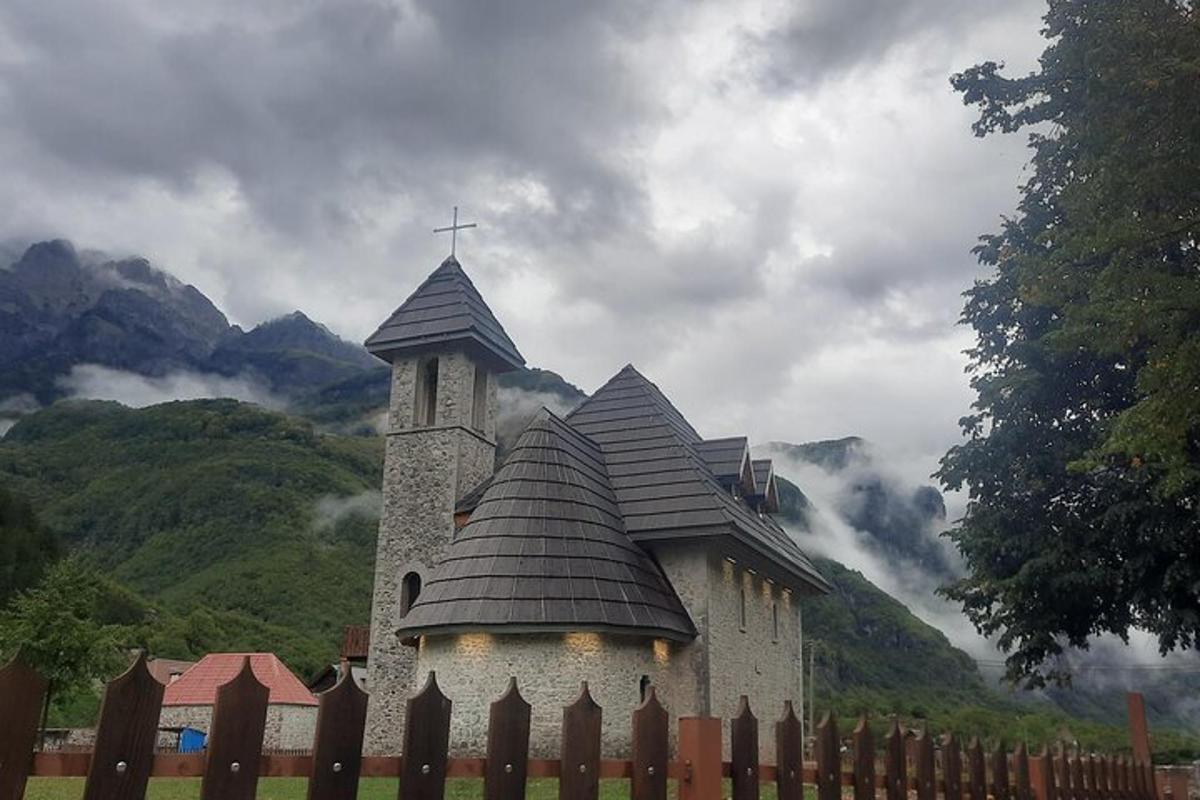 uma igreja com uma cruz no topo de uma cerca