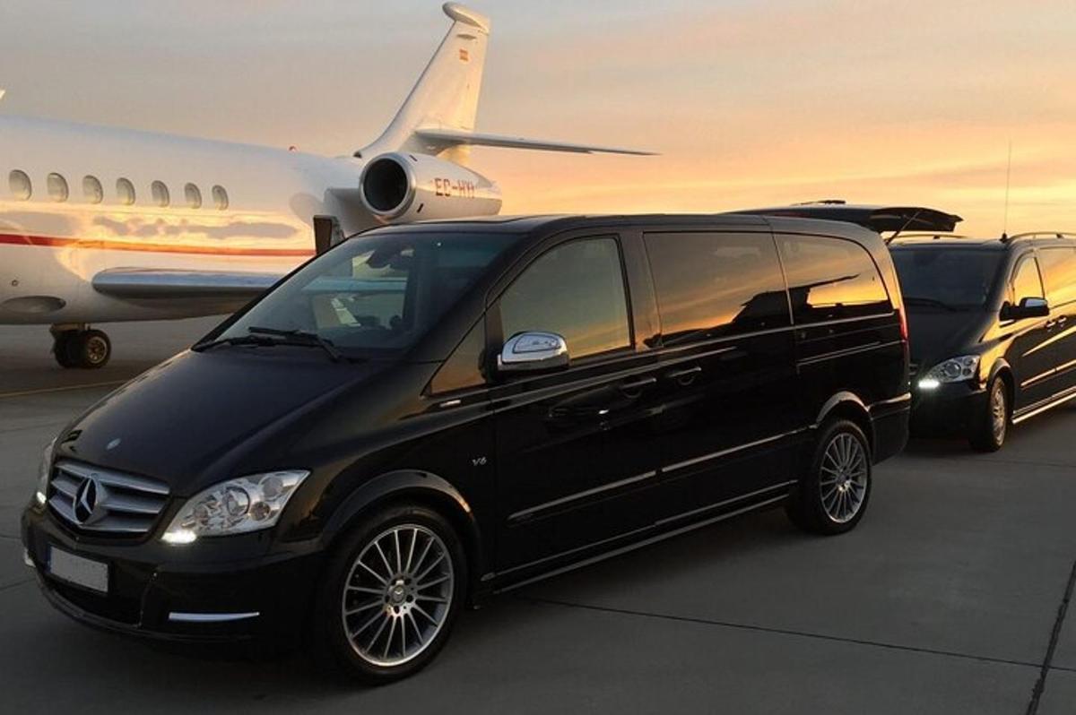 a black van is parked next to an airplane
