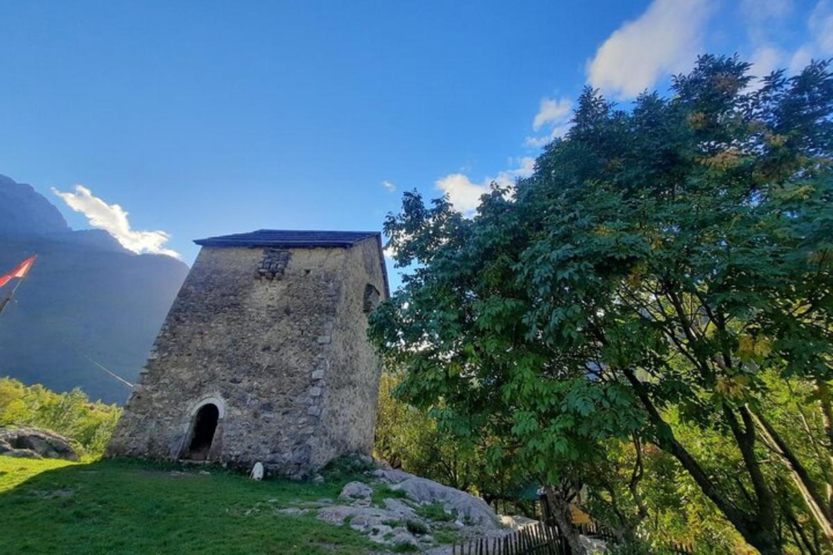 uma torre de pedra situada no topo de um campo verde