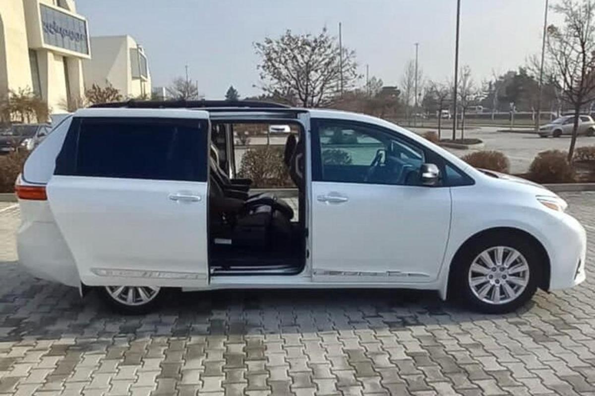 bel kombi z odprtimi vrati na parkirišču