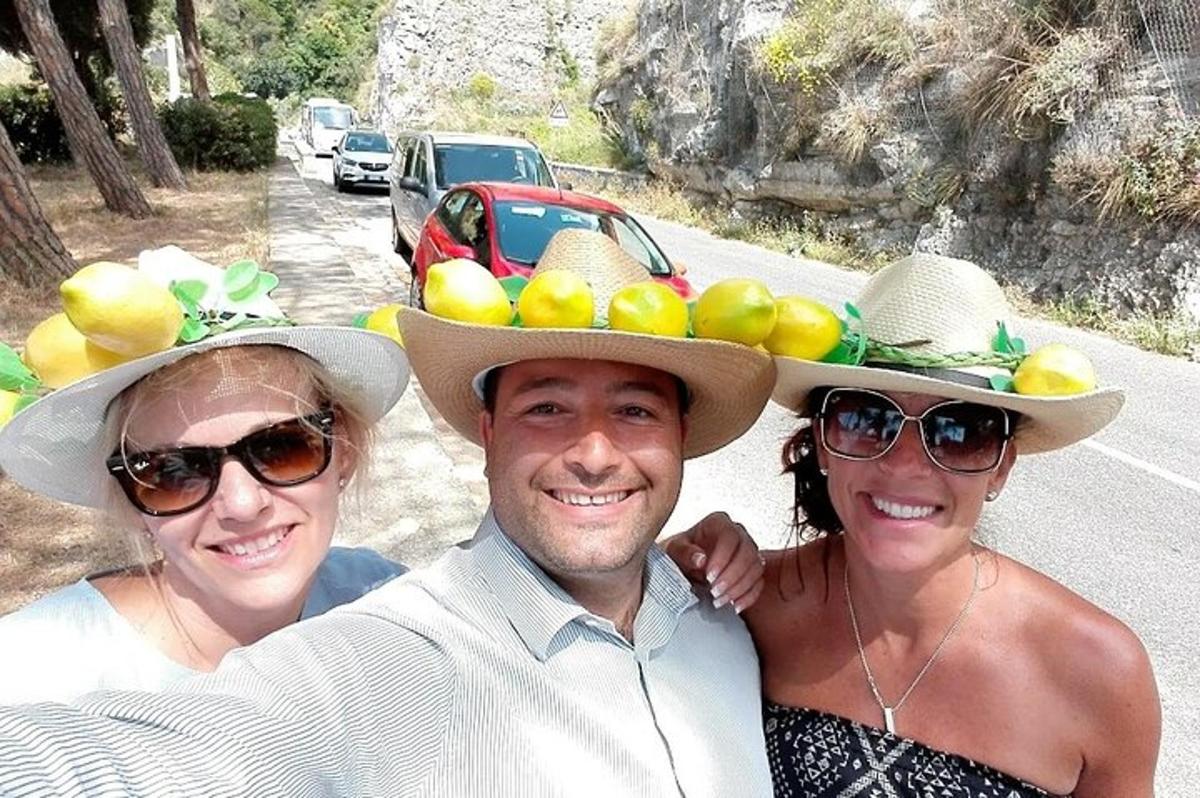 mees ja kaks naist, kellel on peas puuviljadega kübarad