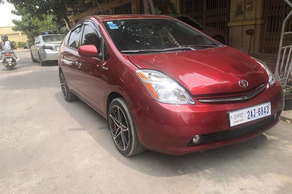 sebuah kereta merah diletakkan di tepi jalan