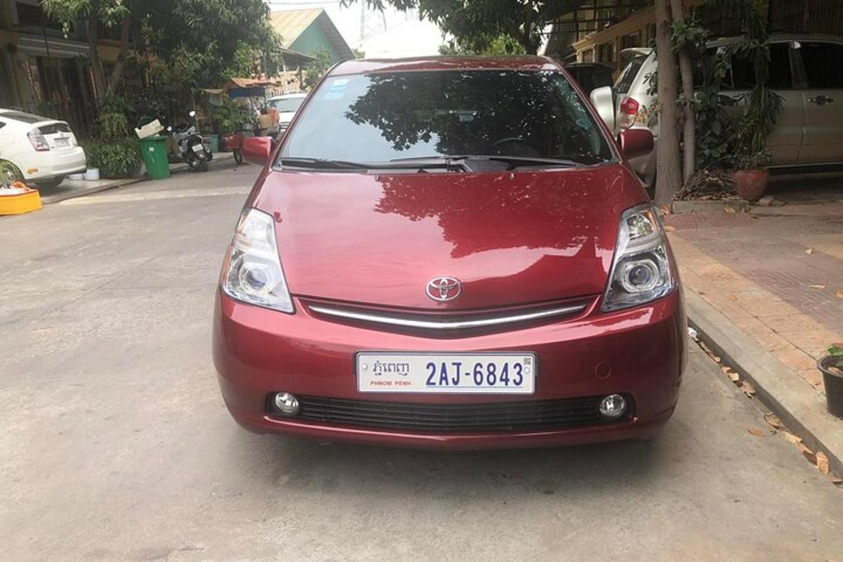 sebuah kereta merah diletakkan di tepi jalan