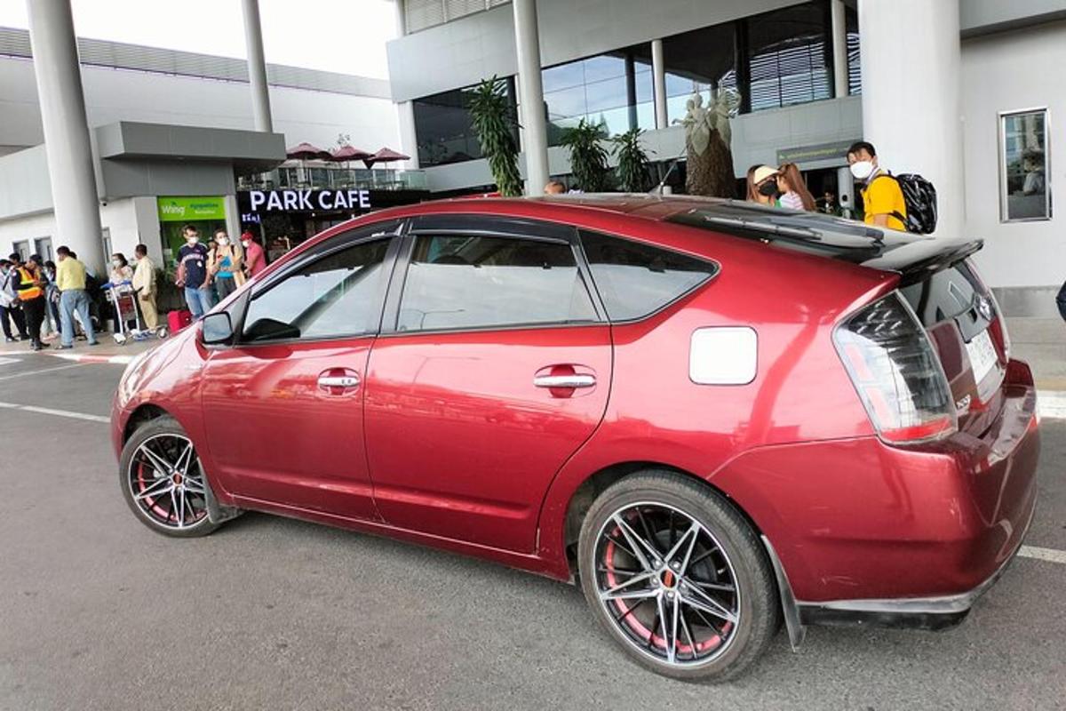 sebuah kereta merah berhenti di hadapan sebuah bangunan