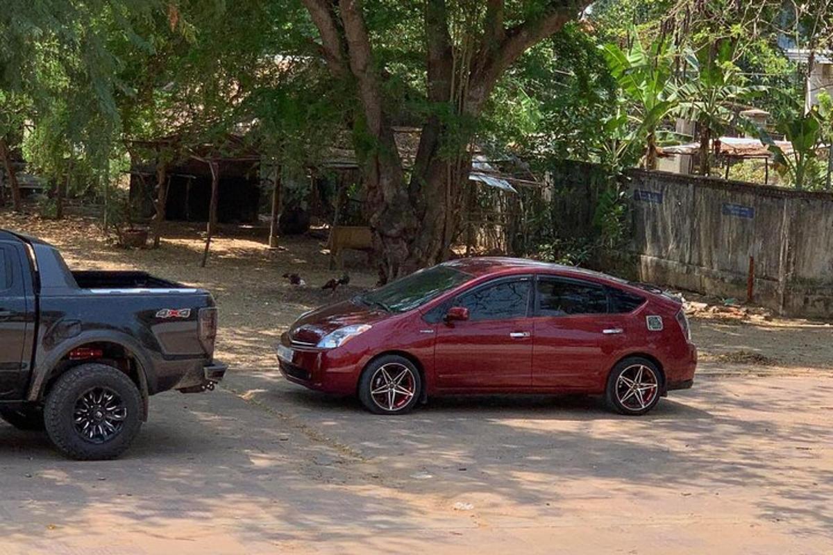 egy piros autó parkolt egy fekete teherautó mellett