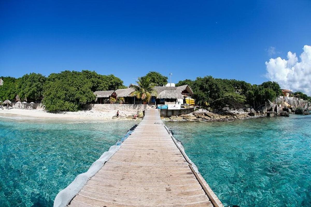 a wooden pathway leading to a resort in the ocean
