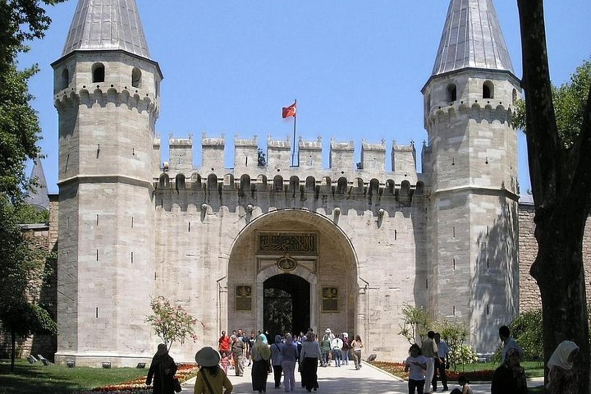 a building with two towers with people walking around it
