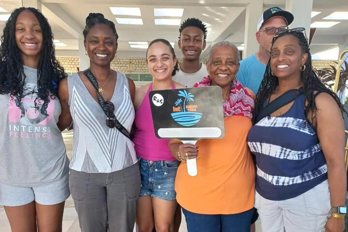 um grupo de pessoas posando para uma foto com um laptop