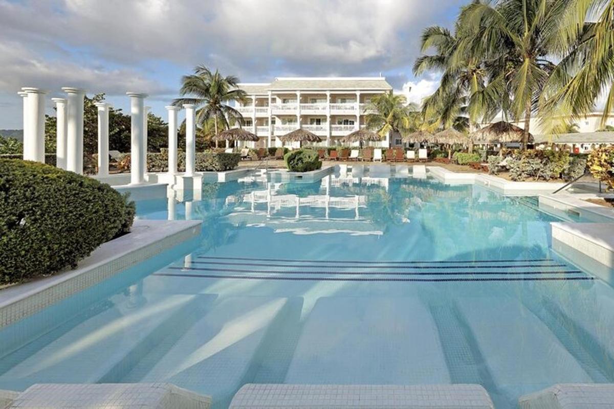a large swimming pool with chairs and a building