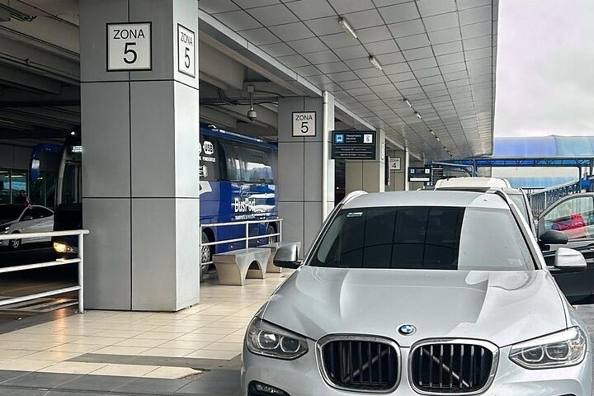 Un coche blanco aparcado junto a una estación de tren.