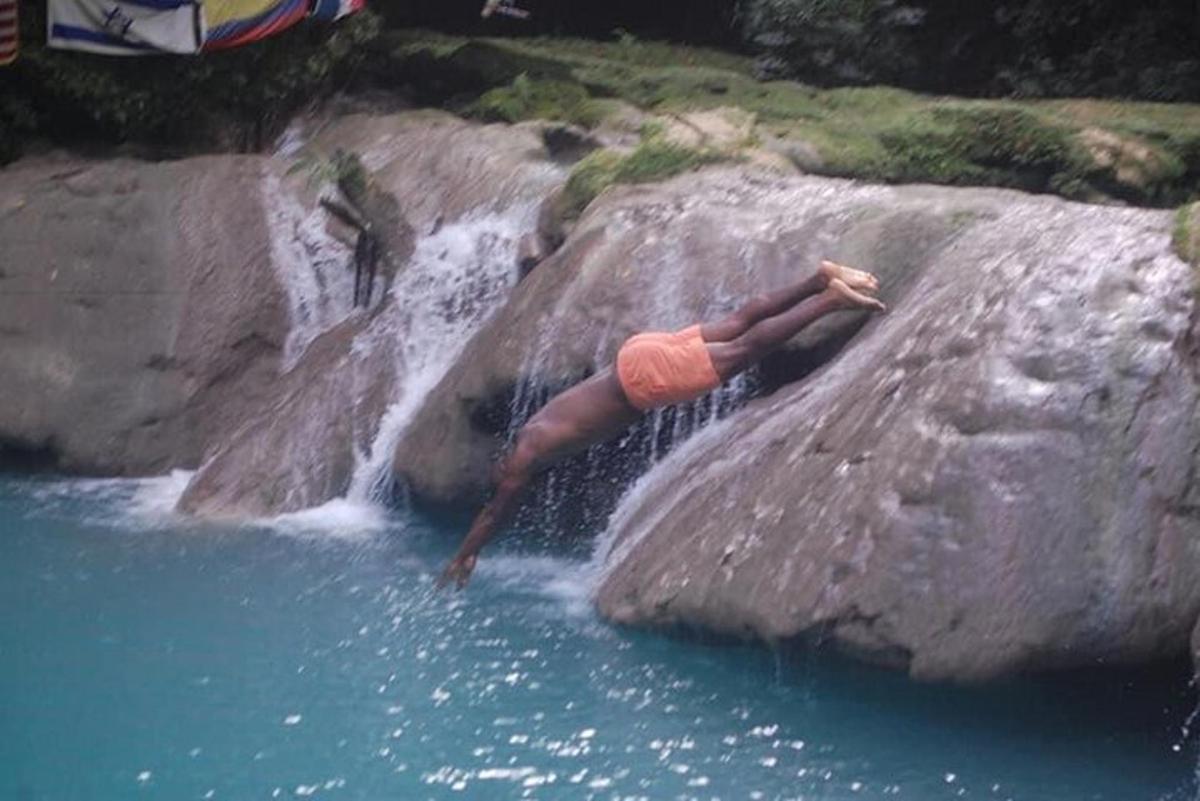 seseorang berbaring di atas batu berhampiran air terjun