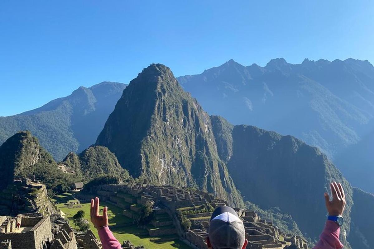 a person standing on top of a mountain with their hands in the air