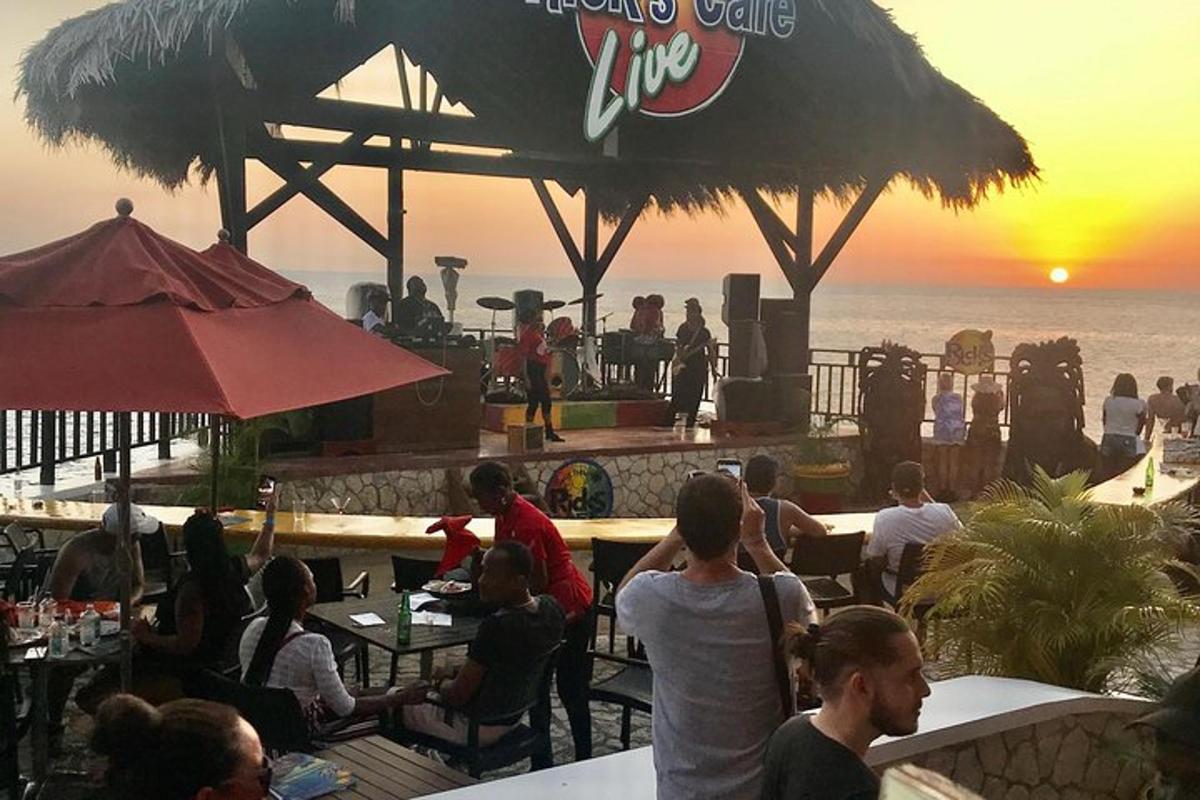 Un grupo de personas sentadas en un bar viendo la puesta de sol
