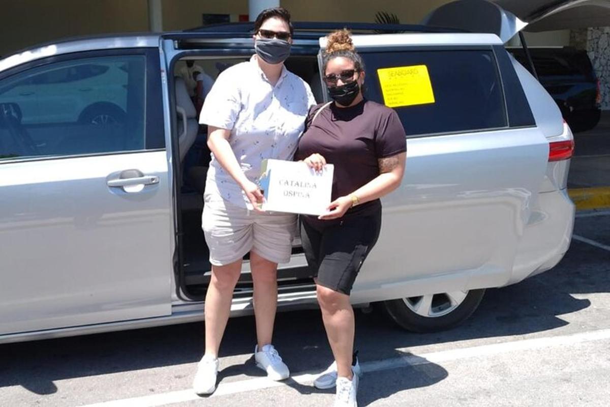 a man and a woman holding a sign in front of a van