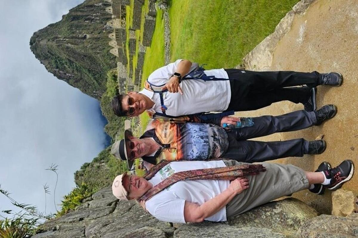 um grupo de três homens em pé no topo de uma montanha
