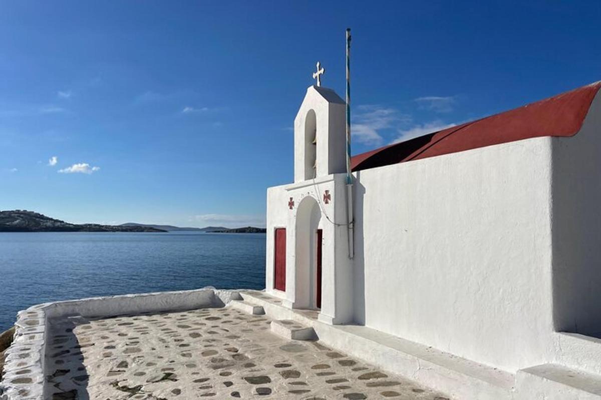 en hvid kirke med et kors på vandet