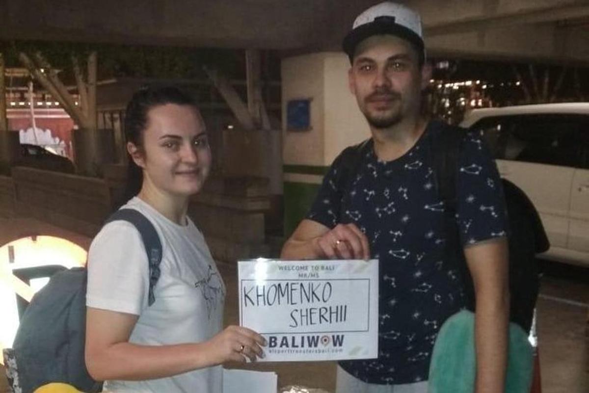 un bărbat care stă lângă o femeie care ține o pancartă