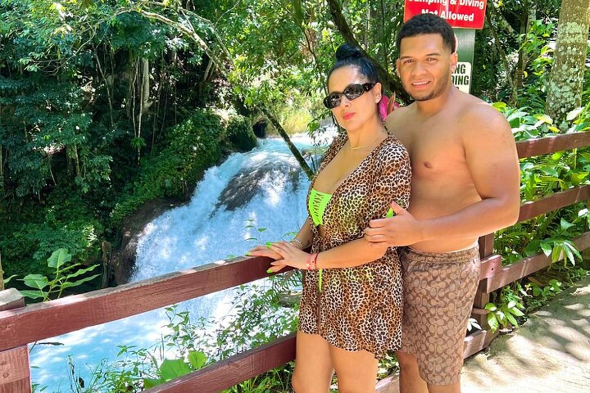 un uomo e una donna in piedi davanti a una cascata