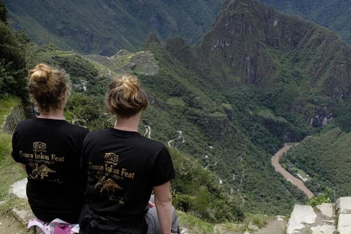 deux personnes assises au sommet d'une montagne surplombant une vallée