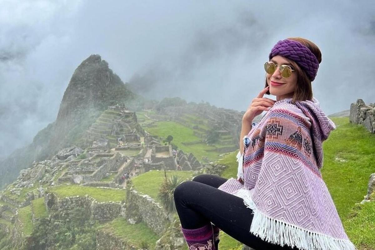 uma mulher sentada no topo de uma montanha com vista