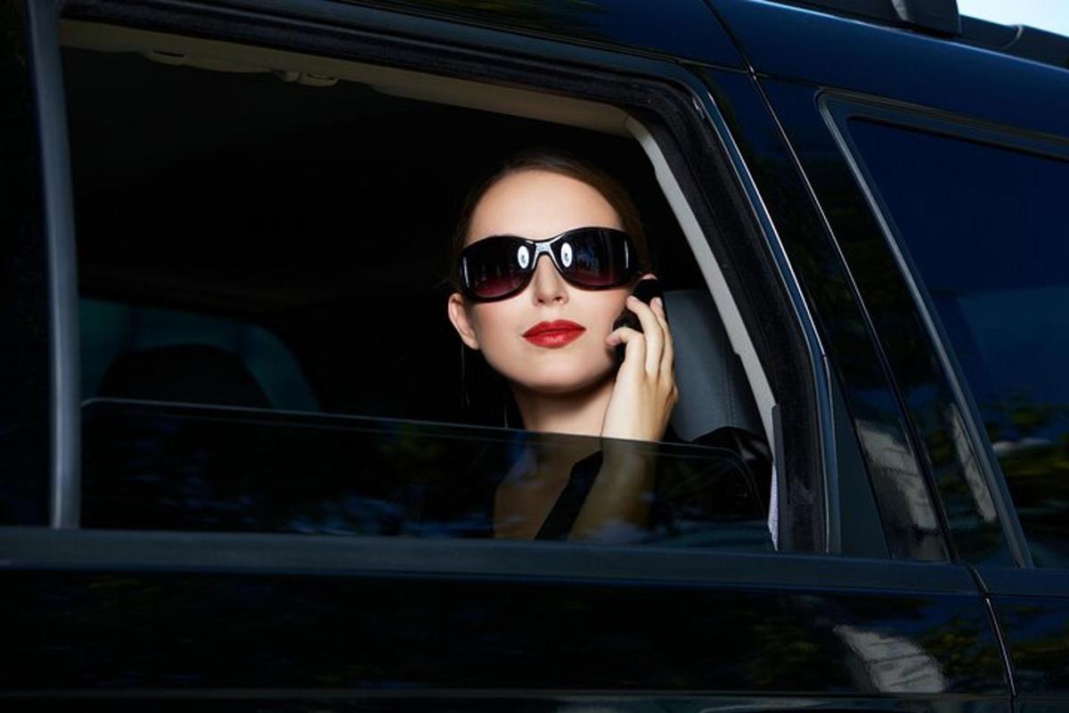 a woman sitting in a car talking on a cell phone