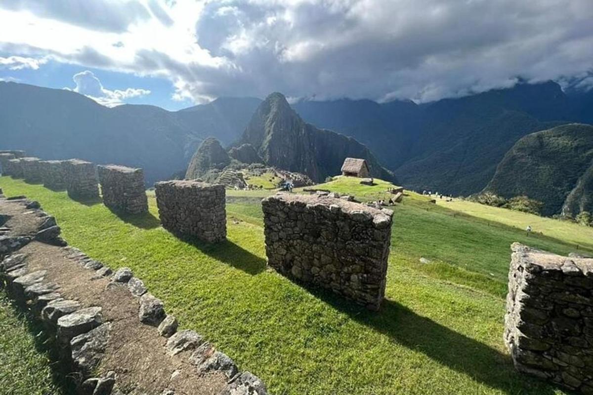 um campo com cercas de pedra e montanhas ao fundo