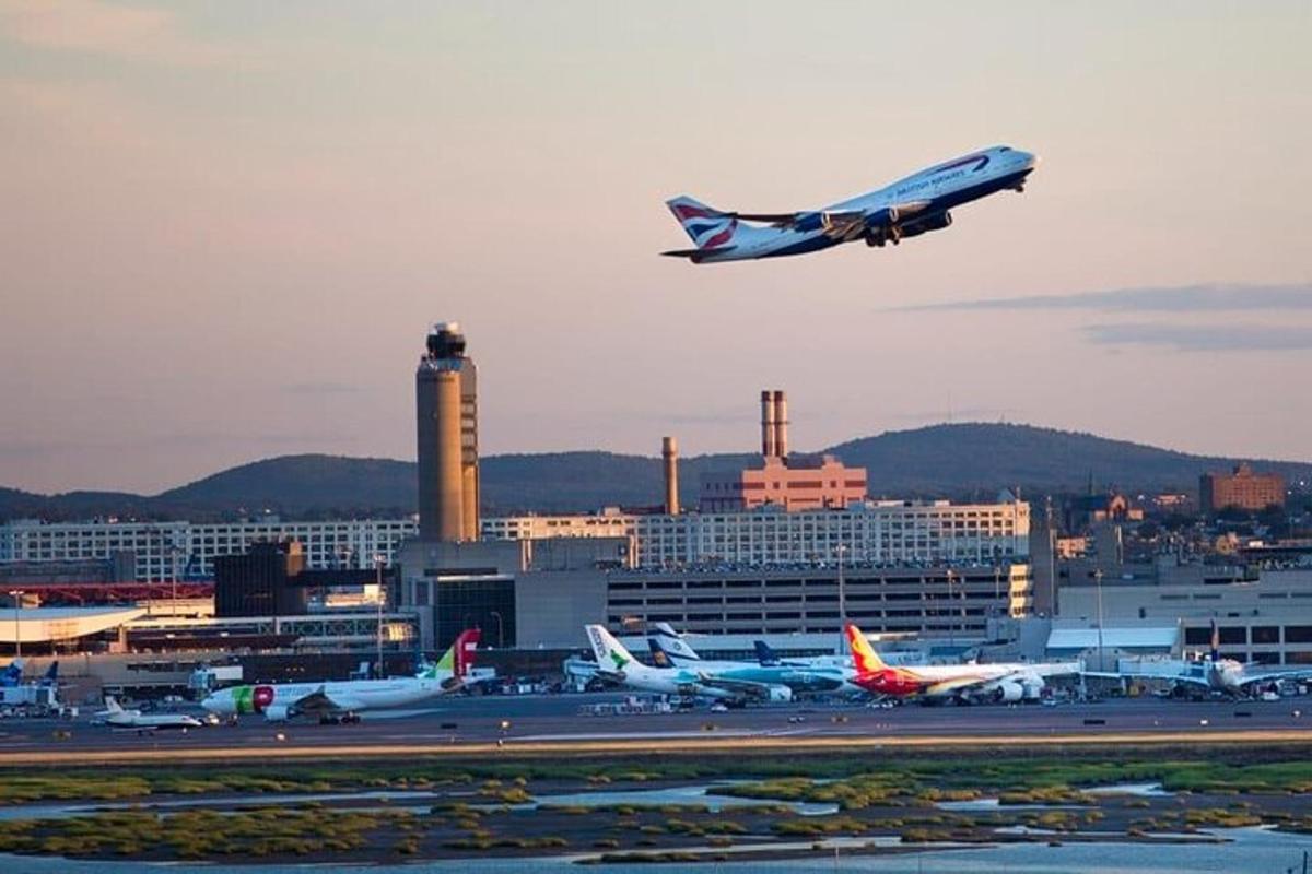 an airplane is flying over an airport with planes