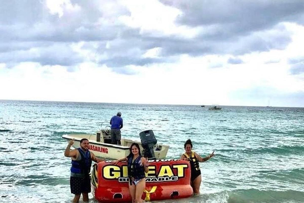 sekumpulan orang berdiri di sebelah bot di lautan